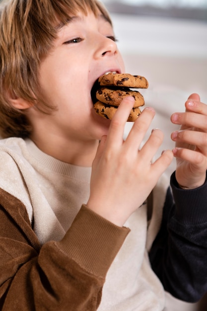 Foto gratuita niño comiendo galletas en casa