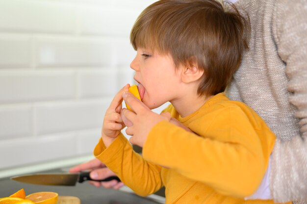 Niño comiendo una naranja