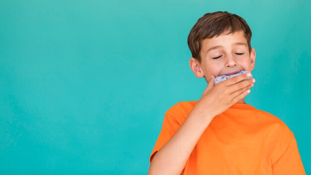 Niño comiendo una rosquilla con espacio de copia