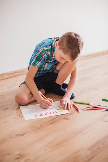 Niño concentrado dibujando para el día de la madre