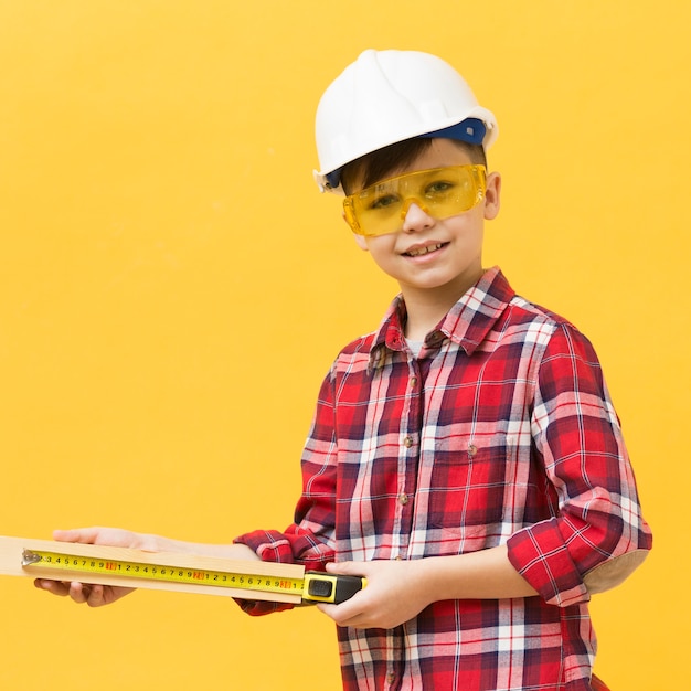 Foto gratuita niño de construcción con cinta métrica