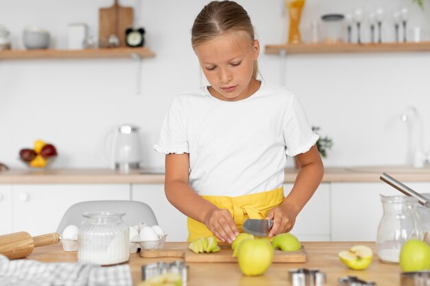 Niño cortando manzanas de tiro medio