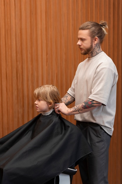 Foto gratuita niño cortándose el pelo en el salón