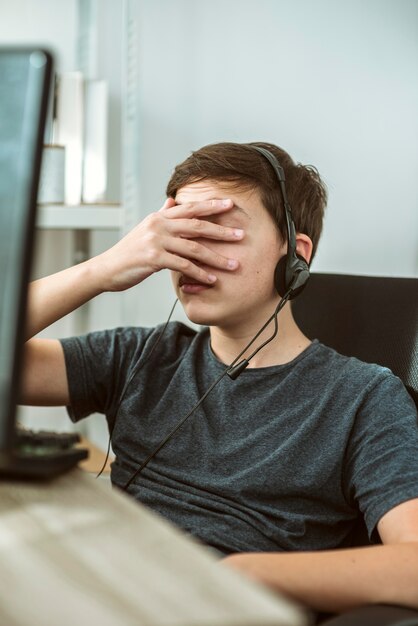 Niño cubriendo su rostro después de perder un juego