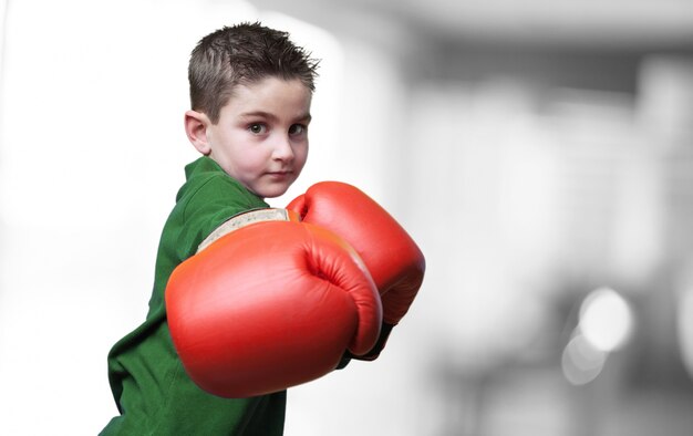 Niño dando un puñetazo con guantes de boxeo