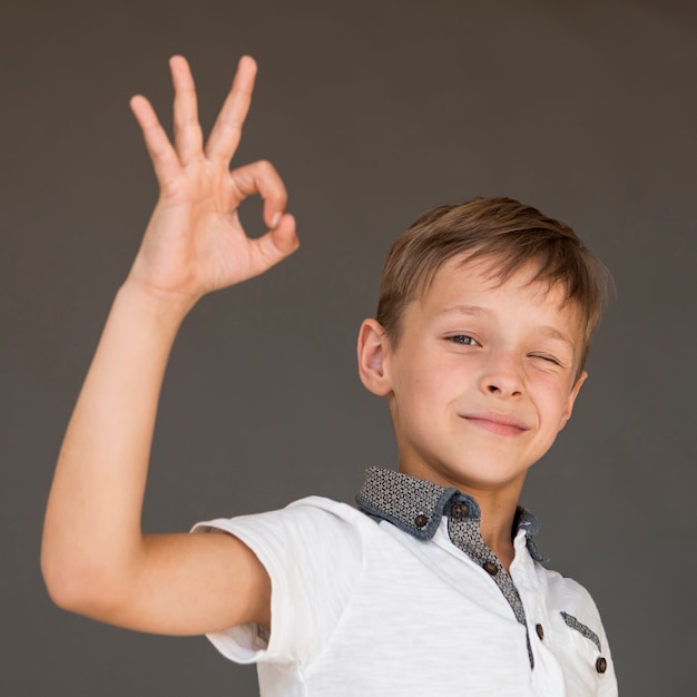 Foto gratuita niño dando la señal ok