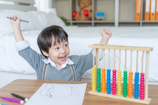 Niño dibujando en papel blanco con disfrutar