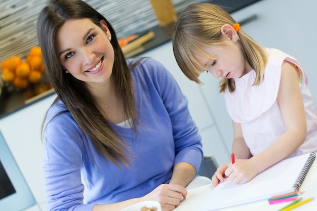 Niño dibujo con lápices de colores con su mamá en casa