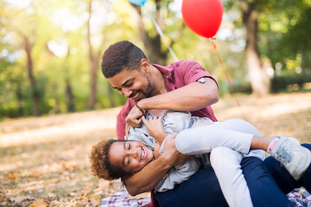 El niño disfruta y se ríe mientras el padre le hace cosquillas