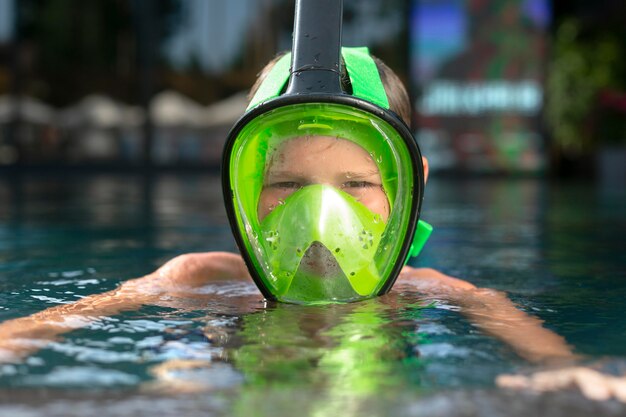 Niño disfrutando de su día en la piscina con máscara de buceo