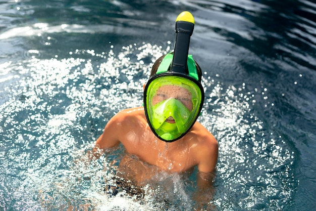 Niño disfrutando de su día en la piscina con máscara de buceo
