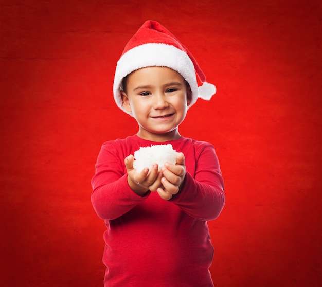 Foto gratuita niño divertido con con nieve en las manos