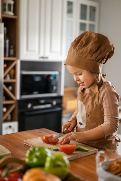 Niño divirtiéndose cocinando en la cocina en casa