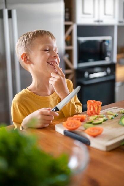 Niño divirtiéndose cocinando en la cocina en casa