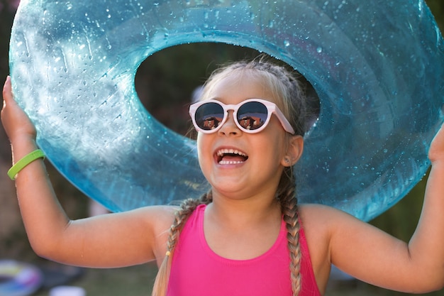 Foto gratuita niño divirtiéndose con flotador junto a la piscina