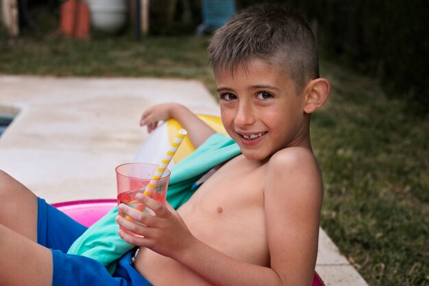 Niño divirtiéndose con flotador junto a la piscina