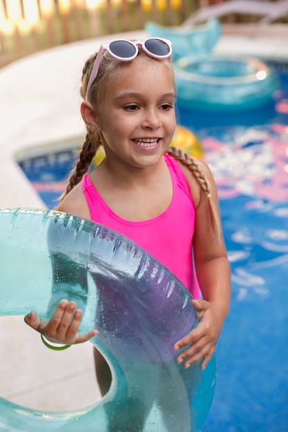 Foto gratuita niño divirtiéndose con flotador junto a la piscina