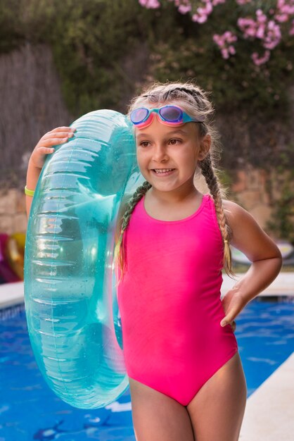 Niño divirtiéndose con flotador en la piscina