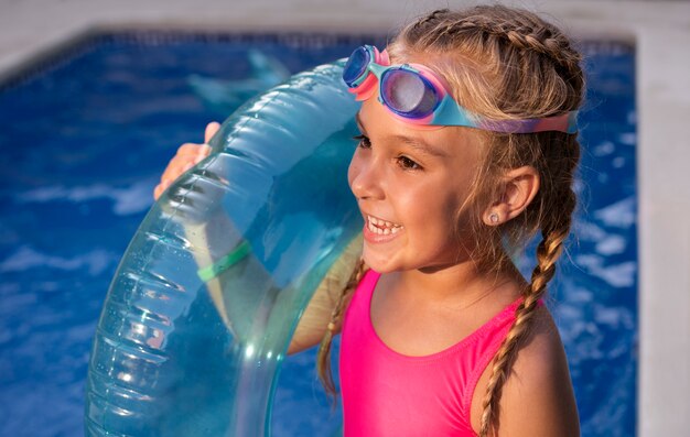 Niño divirtiéndose con flotador en la piscina