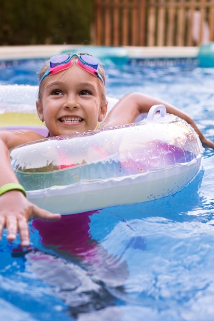 Niño divirtiéndose con flotador en la piscina