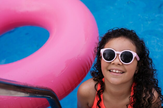 Niño divirtiéndose con flotador en la piscina