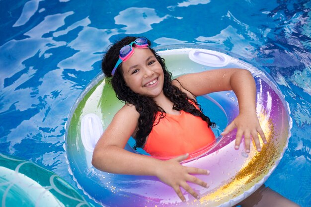 Niño divirtiéndose con flotador en la piscina