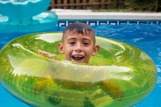 Niño divirtiéndose con flotador en la piscina