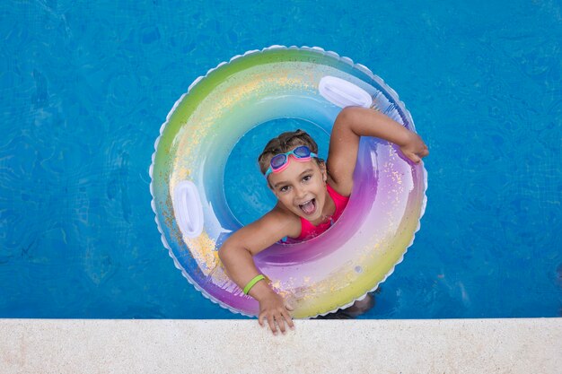 Niño divirtiéndose con flotador en la piscina