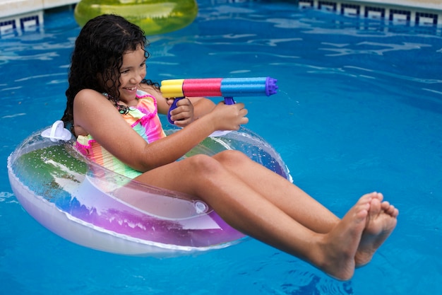 Niño divirtiéndose con flotador en la piscina