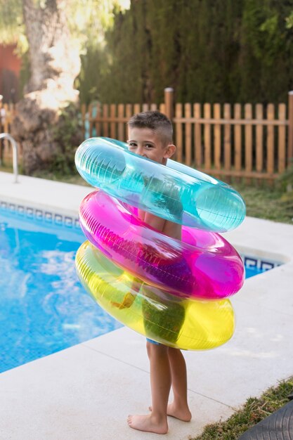 Niño divirtiéndose con flotador en la piscina