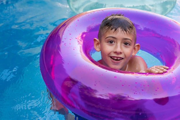 Niño divirtiéndose con flotador en la piscina