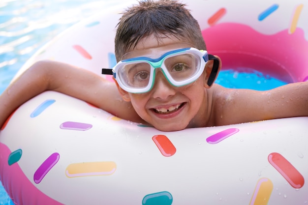 Niño divirtiéndose con flotador en la piscina