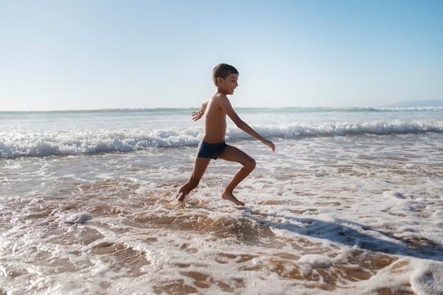 Foto gratuita niño divirtiéndose en la playa