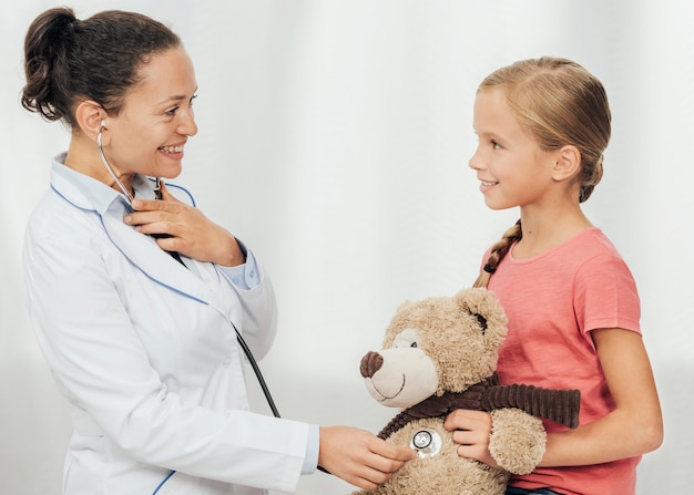 Foto gratuita niño y doctor sonriente de tiro medio