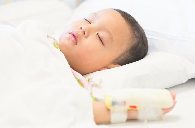 Niño dormido y enfermedad en hospital.