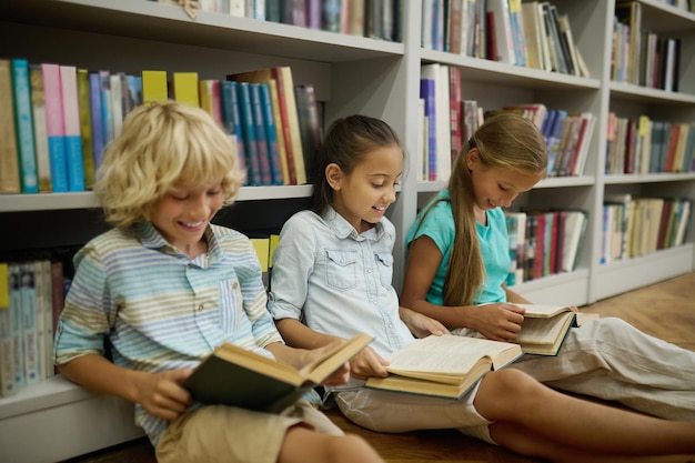 Foto gratuita niño, y, dos niñas, sentado, en, piso, lectura, libros