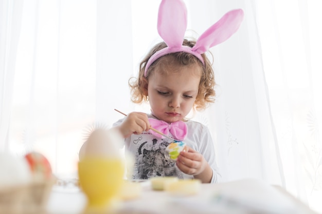 Foto gratuita niño dulce pintando huevos