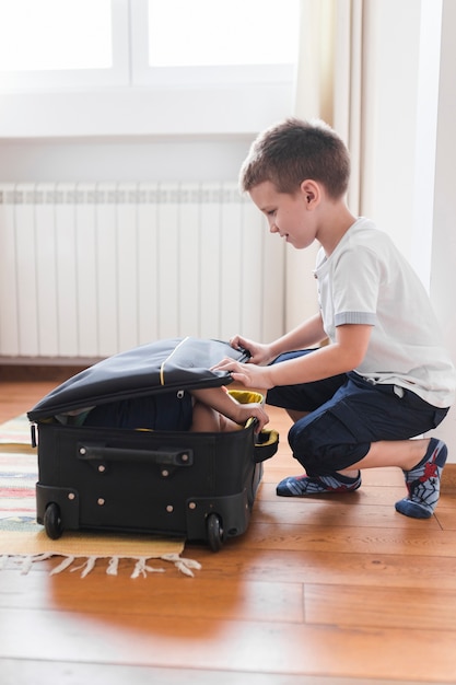 Niño embalando a su hermano en el equipaje