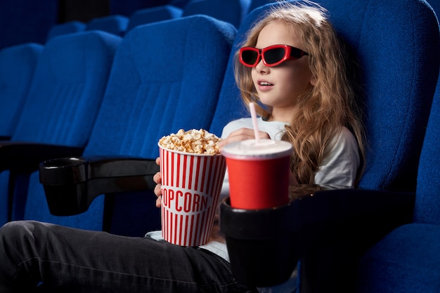 Niño emocionado capturado con una película interesante en la sala de cine