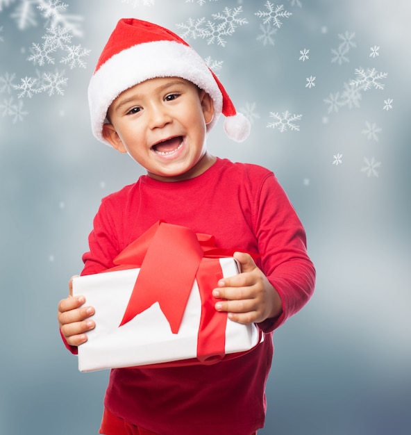 Niño emocionado mostrando su caja de regalo blanca
