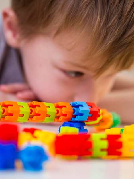 Foto gratuita niño enfocado jugando con colorido juego