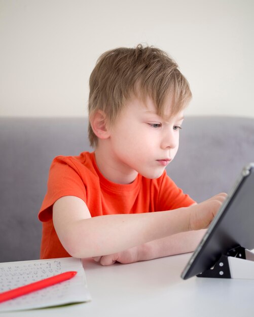 Niño enfocado usando una tableta digital