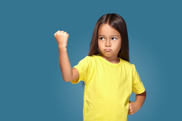 Foto gratuita niño enojado que muestra frustración y desacuerdo sobre fondo azul