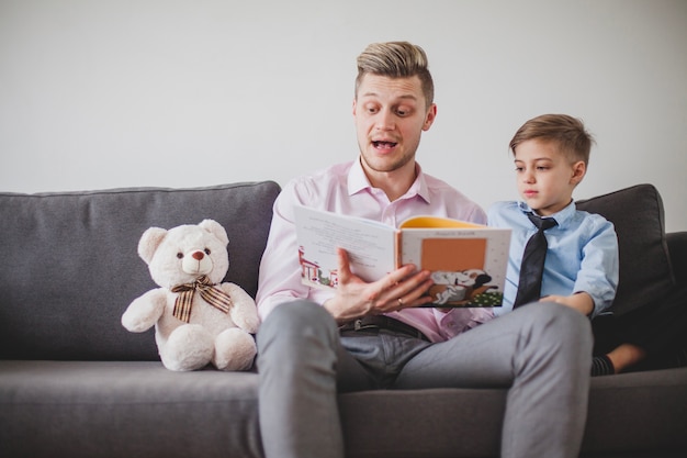 Foto gratuita niño escuchando a su padre mientras le lee un cuento