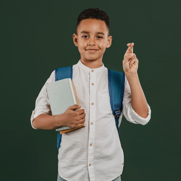 Foto gratuita niño de escuela cruzando los dedos