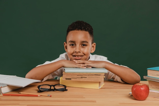 Niño de escuela descansando su cabeza sobre los libros