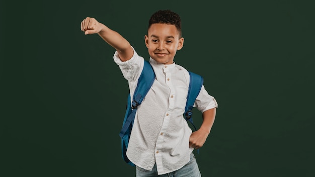 Niño de escuela de pie en una posición de superhéroe