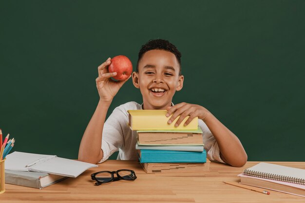 Niño de escuela sosteniendo una deliciosa manzana