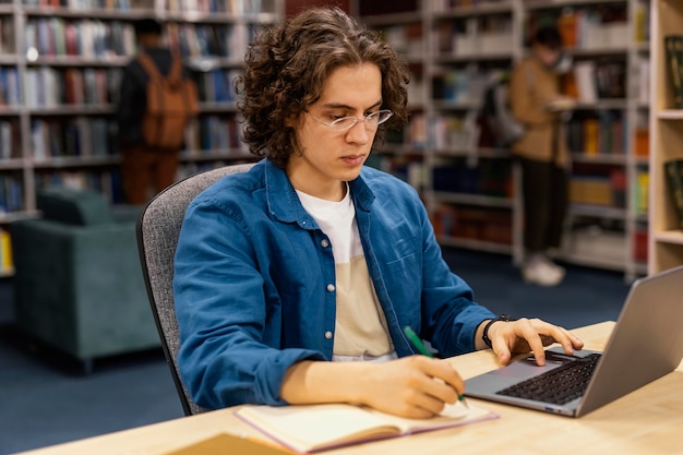 Foto gratuita niño estudiando en la biblioteca de la universidad.