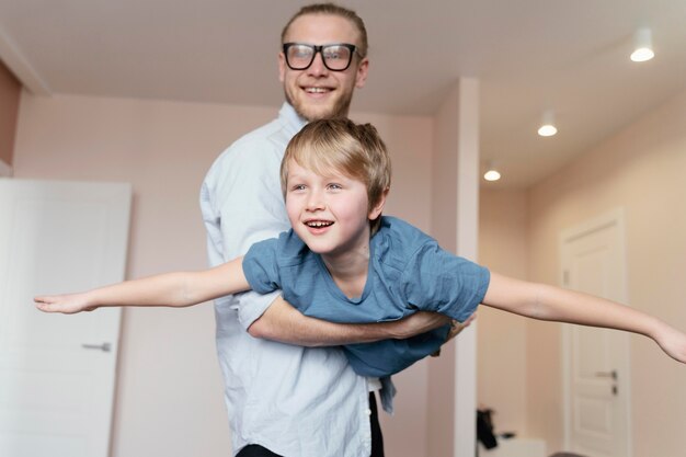 Foto gratuita niño de explotación de padre de tiro medio